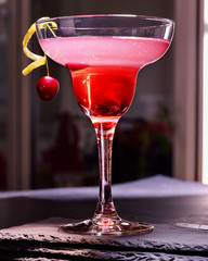 Pomegranate drink with green chery decoration on black background. Cocktail card 86