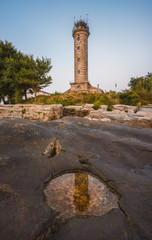 Savudrija Lighthouse on Rocky Coast Reflected in a Puddle, the Most Western Point of the Balkans Peninsula and the Oldest Lighthouse in Croatia (Built 1818)
