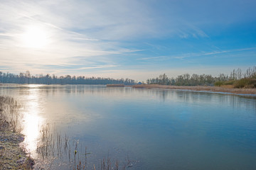 The shore of a frozen lake in sunlight 