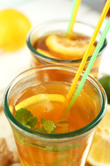 Iced tea with lemon on light wooden background