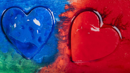 Three-dimensional hand-painted red and blue hearts on a colored background. Gift for Valentine's Day.