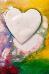 Three-dimensional hand-painted white heart on colorful background. Gift for Valentine's Day.
