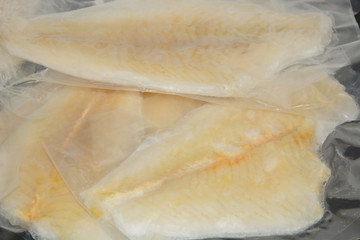 Frozen vacuum packed flounder fillets in airtight plastic packaging