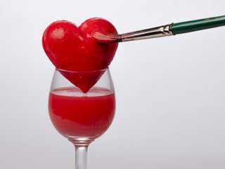 Hand-painted red heart on glass, on a white background