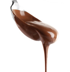 Melted milk chocolate pouring from a spoon, isolated on white