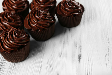 Chocolate cupcakes on light wooden background