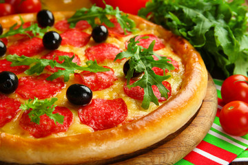 Tasty pizza with salami on decorated wooden table, close up