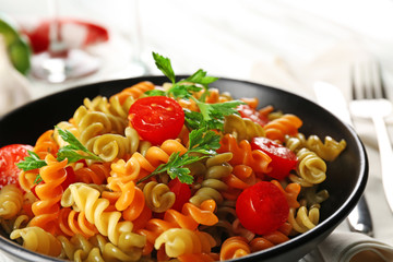 Delicious macaroni dish in black bowl on served grey wooden table
