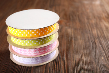 Spools of color ribbon on wooden background