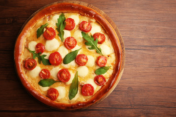 Pizza Margherita with arugula on wooden background