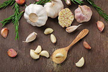 Composition of garlic and rosemary on wooden background