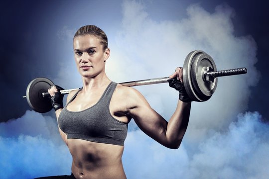 Composite image of muscular woman lifting heavy barbell 