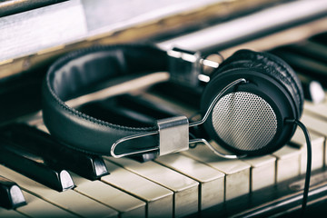 Headphones on piano keyboard, close up