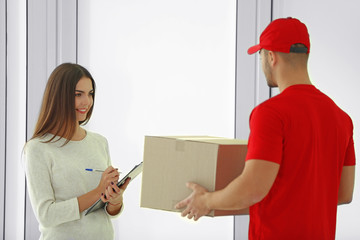 Young woman receiving parcel from delivery man