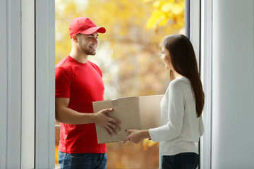 Young woman receiving parcel from delivery man