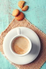 Cup of coffee on color wooden background