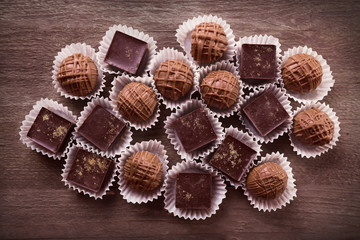 Assorted chocolate candies on wooden background