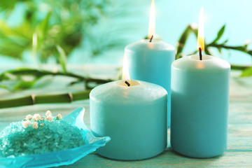 Blue candles with spa salt and bamboo on table