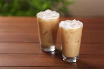 Cups of ice coffee on wooden table