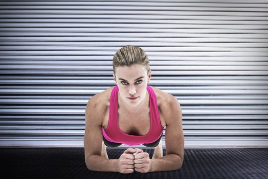 Composite image of  a muscular woman on a plank position