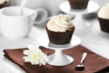 Delicious chocolate cupcake with cream on served table, close up