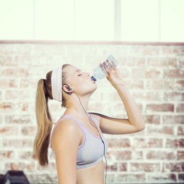 Composite image of sporty blonde drinking water