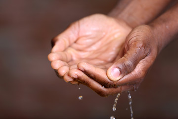 Fototapeta premium Hands washing concept. Water pouring into man hands on brick wall background