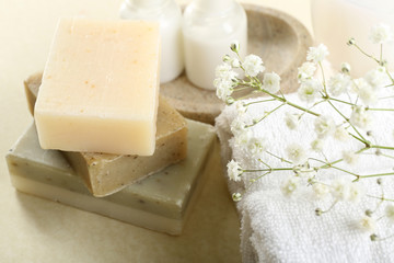 Soap set and towels on a beige background, close up