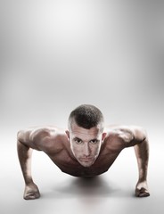 Confident shirtless man doing push ups