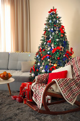 Christmas fir tree with gifts in living room