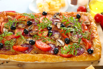 Rectangle delicious pizza and vegetables on the table, close-up