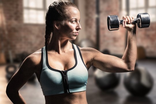 Composite image of fit woman lifting dumbbells