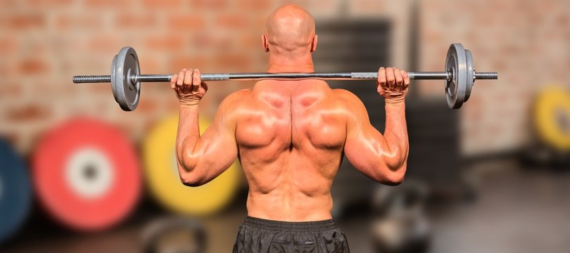 Composite image of rear view of bodybuilder lifting crossfit