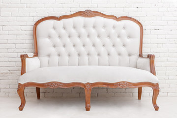 White classical style sofa on white brick wall