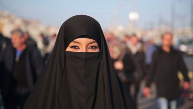 Woman dressed with black headscarf, chador on istanbul street, turkey