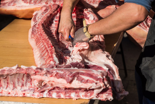 Butcher hands on fresh pork