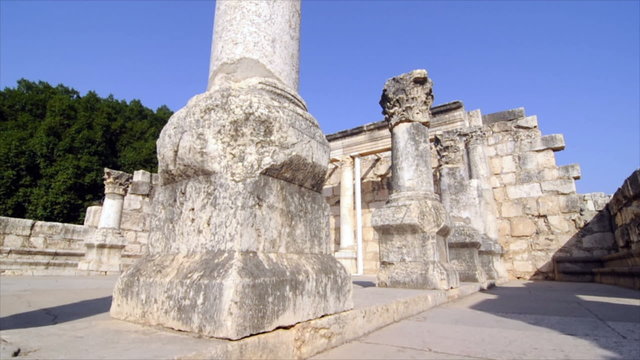 Slow-moving tracking footage of ruined columns near crumbling wall