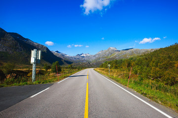 Picturesque Norway road landscape on high mountains, lake and fjord with blue sky in summer day, Norge.