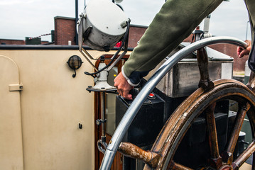 Captain operate an ancient ship steering wheel