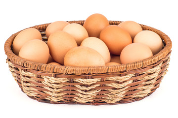 Brown eggs in the basket on white