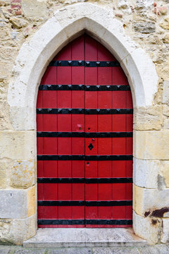 Ancient wood door in a stone wall, Alfama district, Lisbon, Portugal.