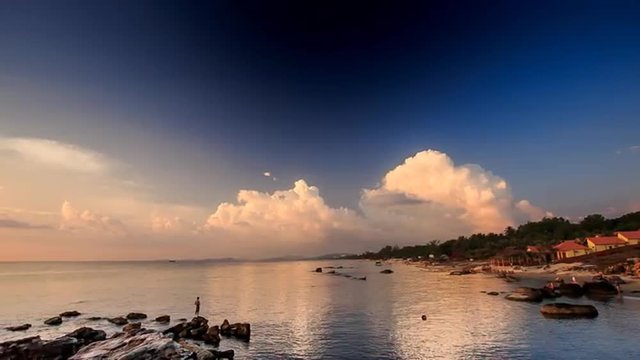 Small Silhouette of Fishman on Beach at Sunset
