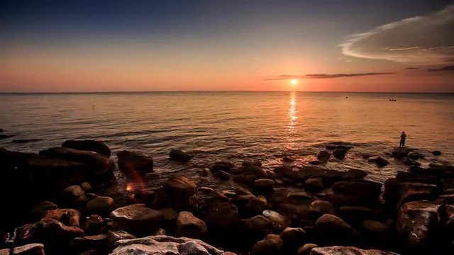 Stone Beach Fisherman Silhouette at Sunset against sky