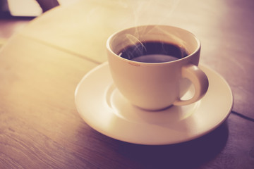 Cup of coffee on wooden table vintage color