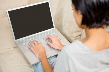 Over shoulder view of brunette using laptop