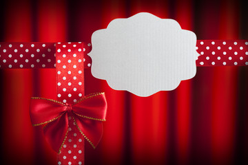 Blank label, ribbon and bow on red background