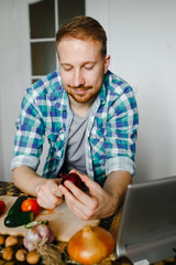 Fototapeta premium Young man cooking in home kitchen