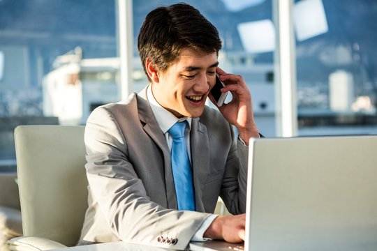 Smiling Asian Businessman Talking On The Phone