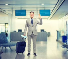 happy businessman in suit with travel bag