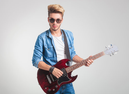 Blonde Guy Playing Electric Guitar While Posing For The Camera